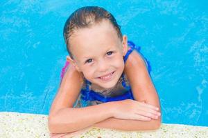 retrato de una linda chica sonriente y feliz en la piscina al aire libre foto