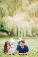 Young romantic couple lying in park and reading books photo