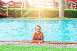 Little adorable girl in outdoor swimming pool photo