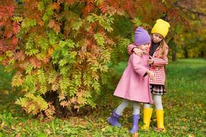 Two adorable girls outdoors in autumn forest photo