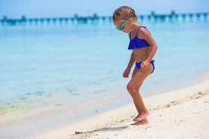 Adorable happy smiling little girl on beach vacation photo