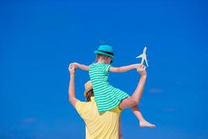 Young man and little girl with miniature of airplane at beach photo
