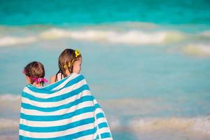 Adorable little girls wrapped in towel at tropical beach photo