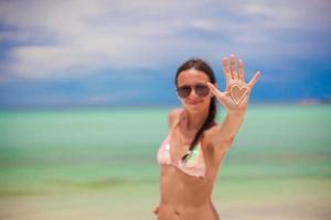 Close-up of girl's hand with heart on the palm painted by suncream photo