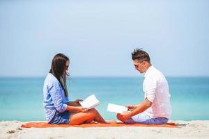 Family with books on the seashore lying photo