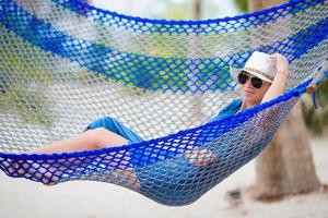 bella mujer relajándose en una hamaca en una playa tropical foto