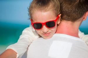 Portrait of father and his adorable little daughter at white beach photo