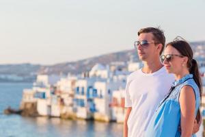 Beautiful young couple at Mykonos island, Cyclades. Tourists enjoy their greek vacation in Greece background famous Mykonos view photo