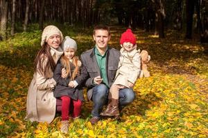 Adorable family of four enjoying a wonderful sunny autumn day in the park photo