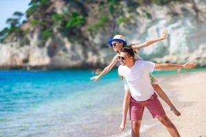 Little girl and happy dad having fun during beach vacation photo