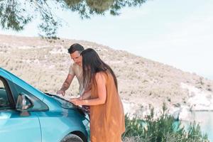 pareja joven turista con mapa viajando en coche foto