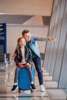 familia feliz con equipaje y tarjeta de embarque en el aeropuerto esperando el embarque foto