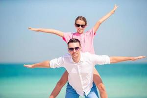 Little girl and happy dad having fun during beach vacation photo