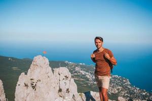 hombre turista al aire libre en el borde del acantilado a la orilla del mar foto