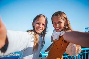 Little smiling girls in mountains take selfies photo