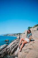 Tourist woman outdoor on edge of cliff seashore photo