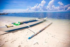 Small Fishing boat on the white tropical beach photo