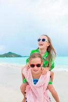 Adorable little girls enjoying time together on the beach photo