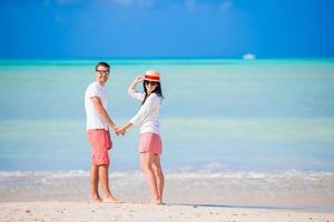 Lovely couple walking on the beach and enjoying summer vacation photo