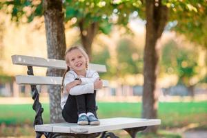 Adorable little girl at beautiful autumn day outdoors photo