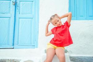 linda chica en la calle del típico pueblo tradicional griego en la isla de mykonos, en grecia foto