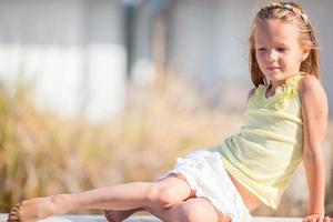 Portrait of adorable little girl in yoga outdoor on vacation photo
