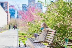 Sunny spring day on New York's High Line. Little girl enjoy early spring in the city outdoors photo