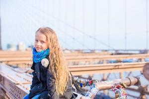 Adorable little kid at Brooklyn Bridge in New York city with view on the road photo