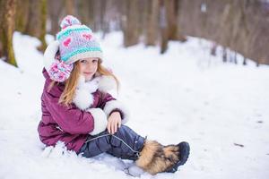 adorable niña feliz divertirse en invierno día nevado al aire libre foto