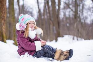 adorable niña feliz divertirse en invierno día nevado al aire libre foto