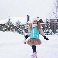 Adorable little girl skating in winter snow day outdoors photo