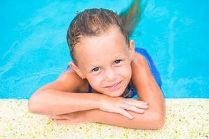 Little adorable girl in outdoor swimming pool photo