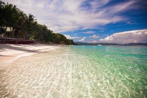 playa tropical con arena blanca y un bote pequeño foto