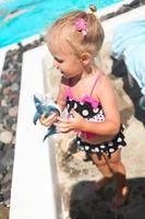 adorable niña cerca de la piscina durante las vacaciones griegas en santorini foto