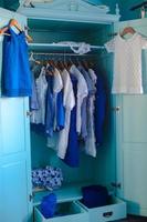 Dressing closet with blue clothes in the closet photo