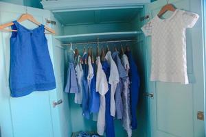 Dressing closet with blue clothes in the closet photo