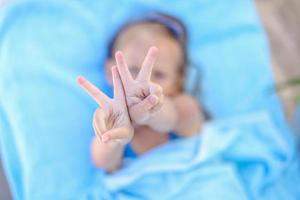 Little girl showing thumbs up outdoor photo