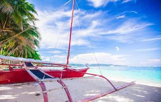 barco rojo filipino en la playa de arena blanca en la isla de boracay, filipinas foto