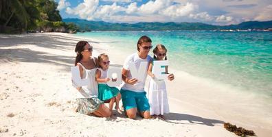 Young family and two kids with word LOVE on tropical vacation photo