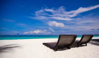 sillas de playa en una hermosa isla de arena blanca foto