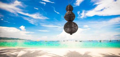 Unusual lantern on the white beach background blue sky photo