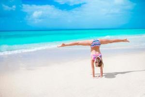 Adorable little girl at beach during summer vacation photo