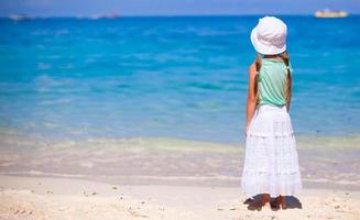 niña dulce en una playa tropical con agua turquesa foto