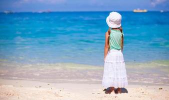 Little sweet girl on a tropical beach with turquoise water photo