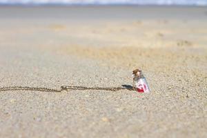 botella pequeña en la playa de arena blanca de fondo el mar turquesa foto