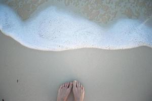 Women beautiful legs on white sandy beach photo