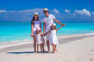 Family of four on caribbean beach summer vacation photo