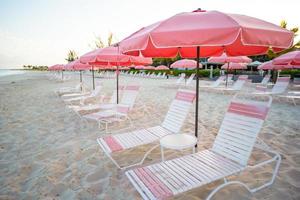 Tropical empty sandy plage with umbrella and beach chair photo