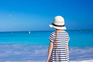 Adorable little girl at white beach during summer vacation photo