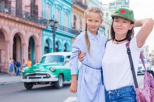 Family of mom and little in popular area in Old Havana, Cuba. Little kid and young mofther outdoors on a street of Havana photo